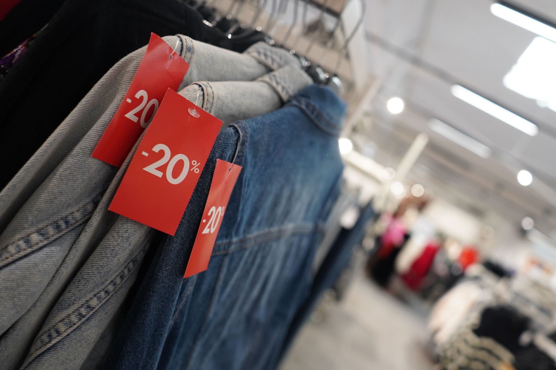 close-up photo captures a row of clothes hanging neatly in a shop.